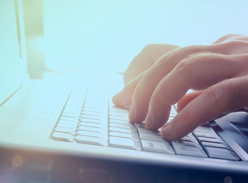 A developer typing on a laptop computer keyboard