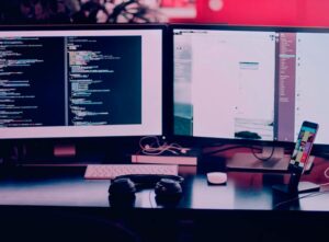 Two computer monitors sitting on top of a desk