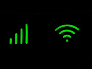 Glowing green Wi-Fi and signal icons on black background