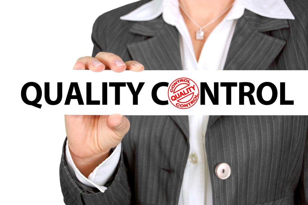 a women holds a plate labeled "quality control" 