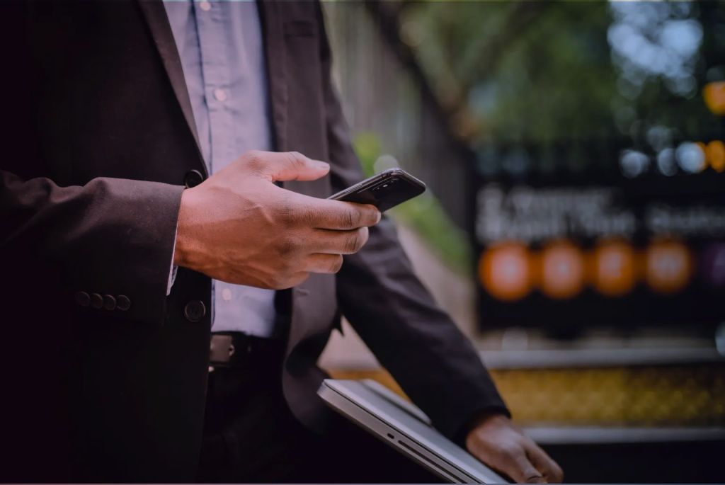 A man in a suit is holding a telephone in the hand