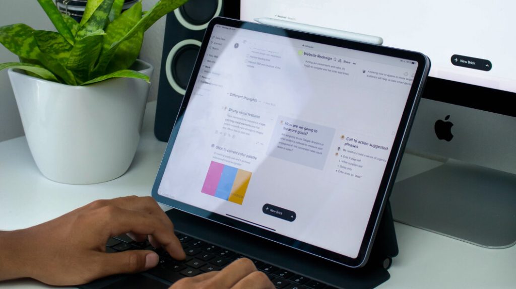 Developer typing on a tablet with a keyboard attached