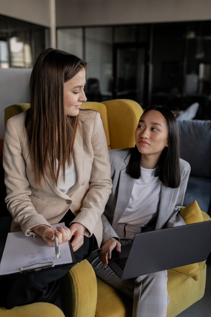 Two graphic designers collaborating on a project on a laptop